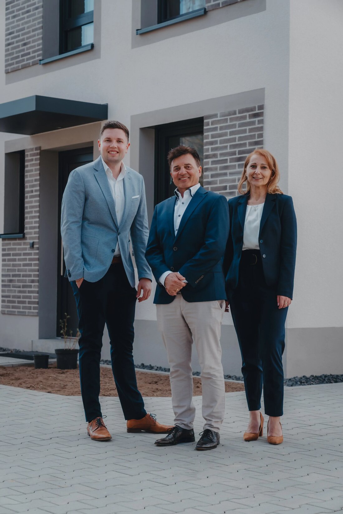 Das Wengerter-Team vor einem fertiggestellten Haus — Michael Bosse, Dr. Heinrich Wengerter und Zana Barisic
